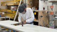 Worker wearing protective gear when finishing a sink cutout.